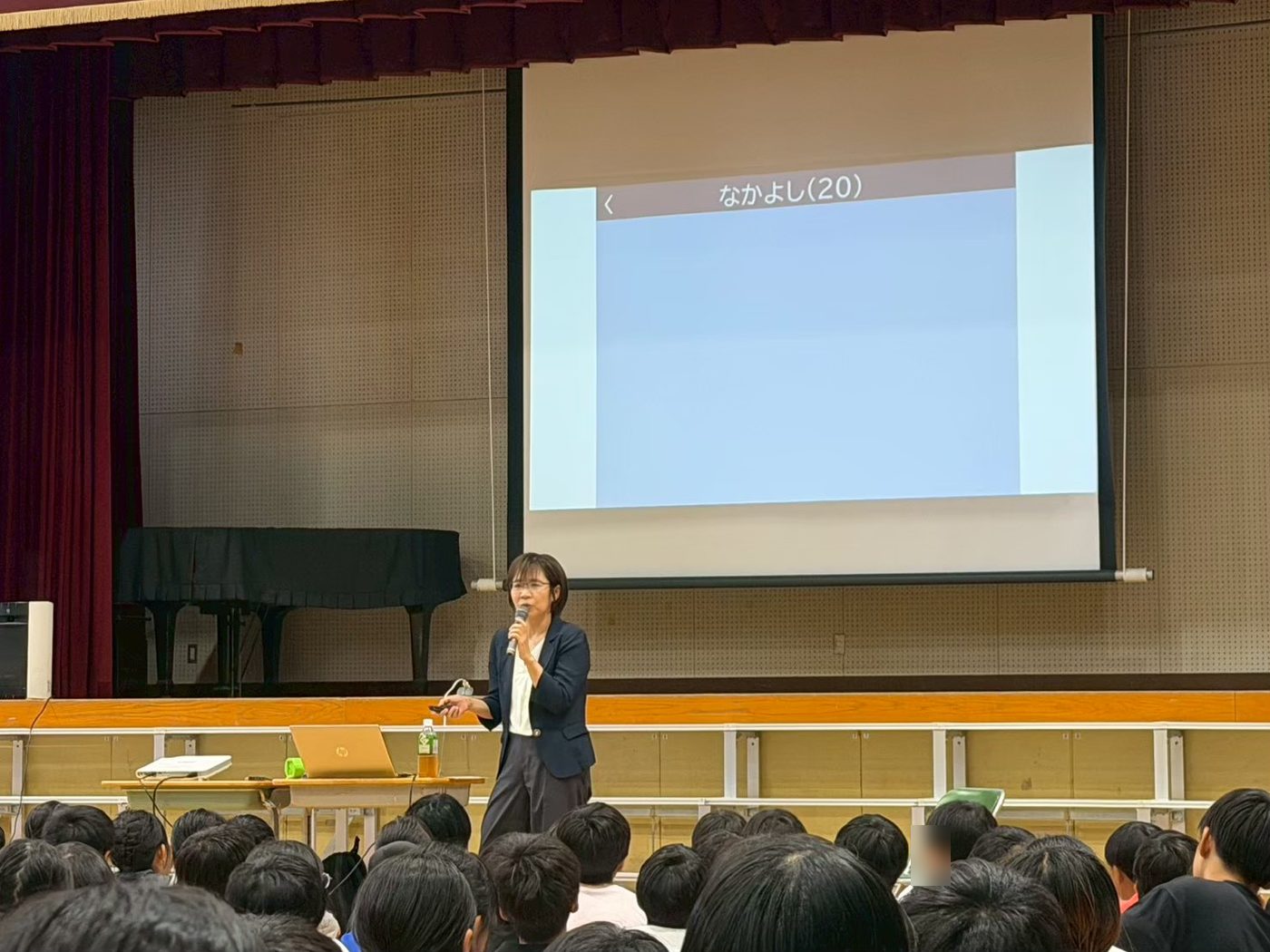 スクリーンの前でマイクを持って話す林美穂先生