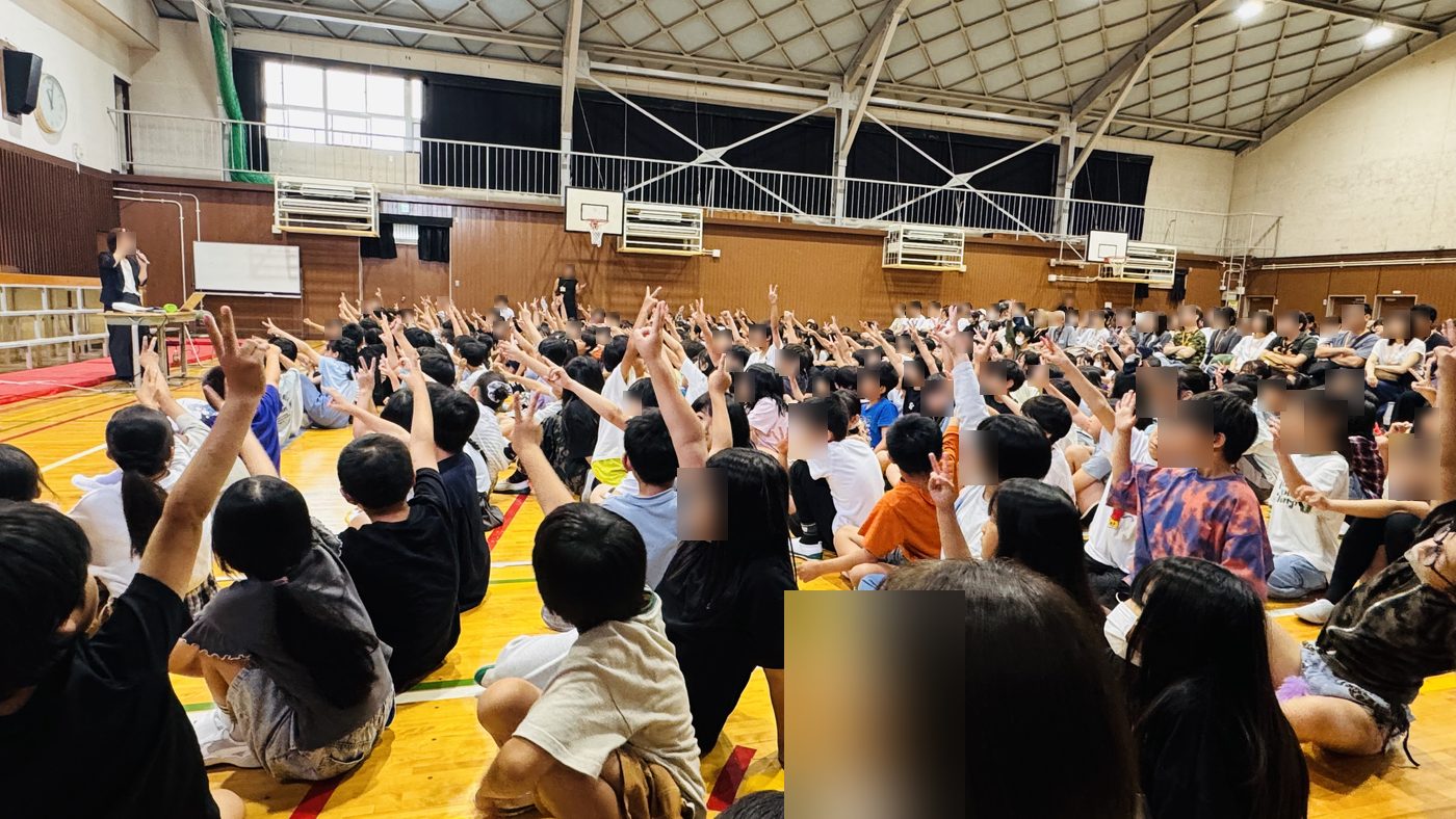手を挙げる子どもたちを横から見たようす